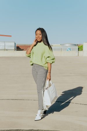 Wearing a green chunky knit sweater from Topshop with skinny gingham pants and a white tote bag as a winter to spring transition outfit